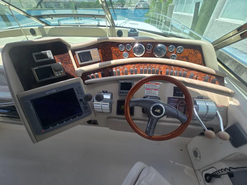 Slide: The Image of 1998 Sea Ray 500 Sundancer helm with wood accents and modern navigation equipment. - 11