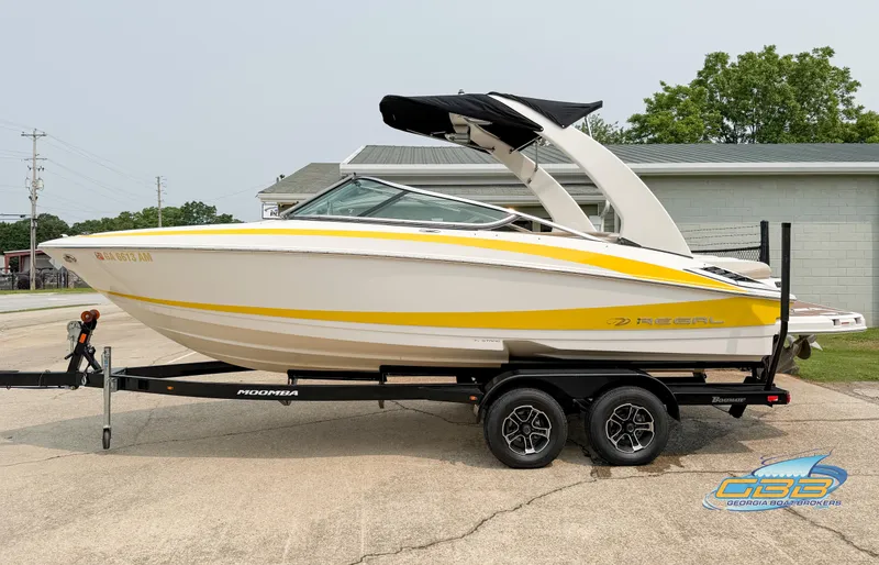 The Image of 2010 Regal 2300 Bowrider boat on trailer, featuring sleek yellow and white design. - 0