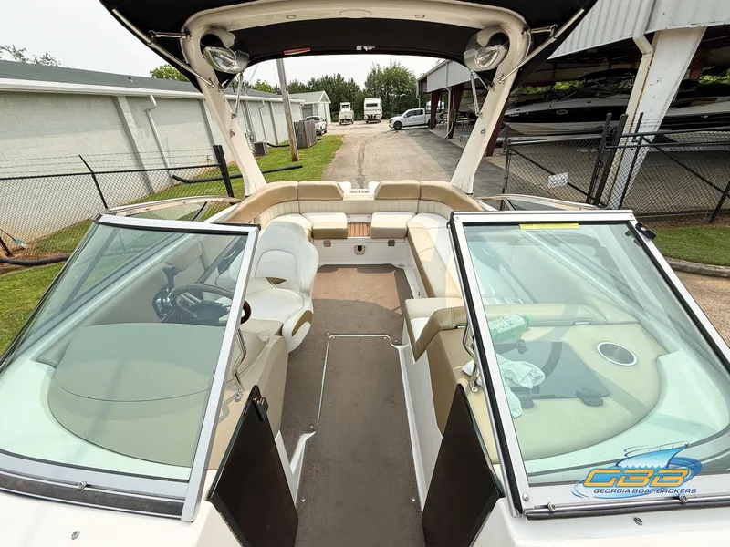 Slide: The Image of 2010 Regal 2300 Bowrider boat interior with seating and steering wheel, parked outdoors. - 11