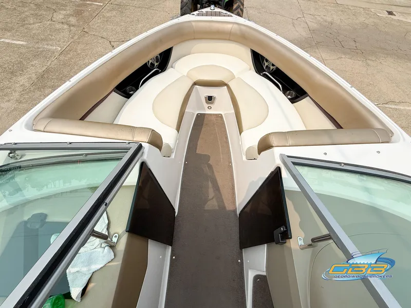 Slide: The Image of 2010 Regal 2300 Bowrider boat interior with beige seating and open windshield. - 12