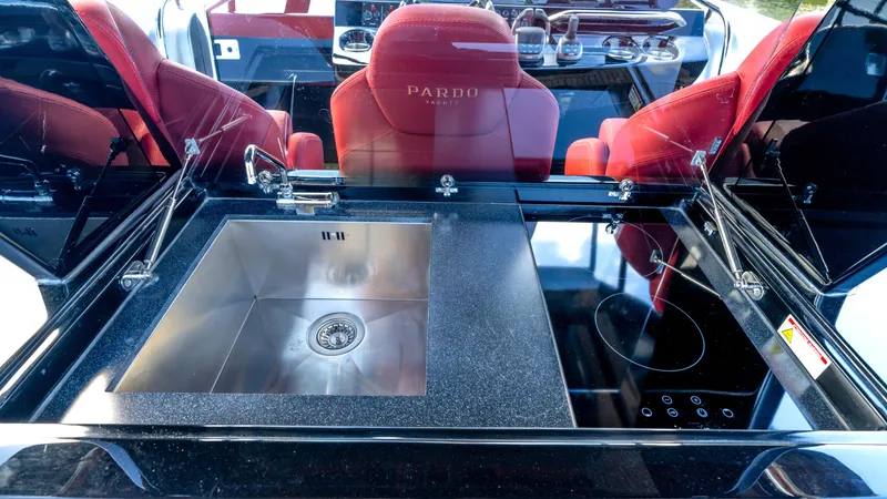 Slide: The Image of Luxurious Pardo 43 yacht kitchen with sleek sink and stove, featuring red seating, 2022 model. - 23