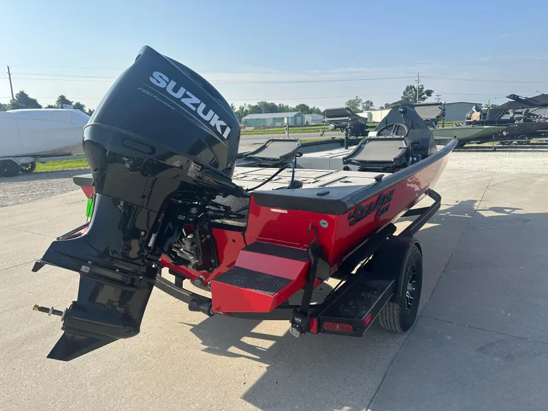The Image of 2025 SeaArk Flex 19 boat in red and black on a trailer, outdoor display. - 1