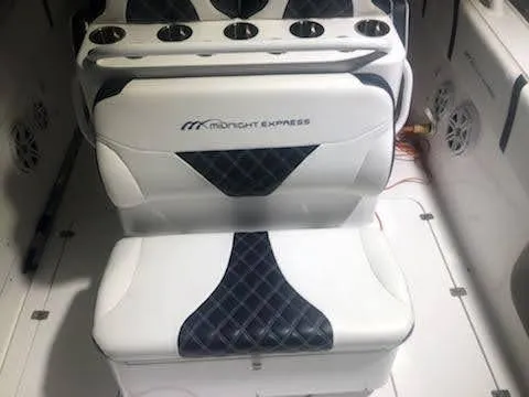 Slide: The Image of 2019 Midnight Express 39 Cuddy boat interior with cushioned seating and cup holders. - 10