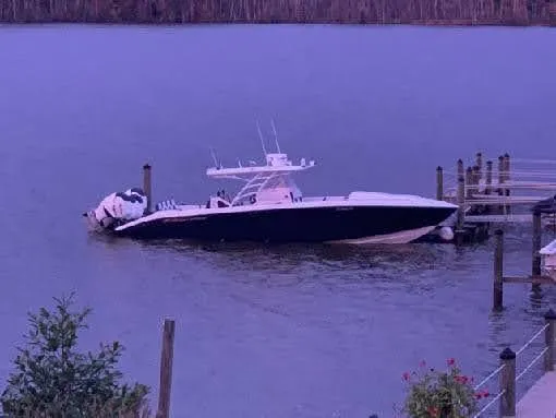 Slide: The Image of 2019 Midnight Express 39 Cuddy boat docked on calm water at sunset. - 2