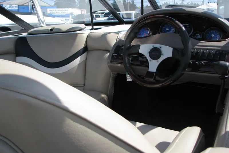 Slide: The Image of Interior of a 2001 Tigé 20ci boat featuring steering wheel and dashboard controls. - 10
