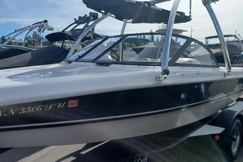 Slide: The Image of 2001 Tigé 20ci boat with sleek design, parked on a trailer under clear skies. - 5