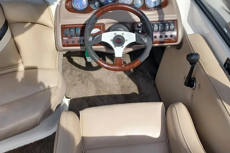 Slide: The Image of 2001 Tigé 20ci boat interior with steering wheel, dashboard, and beige seating. - 7