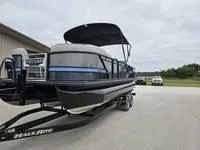 Slide: The Image of 2025 Sylvan L-3 DLZ pontoon boat on trailer, parked outdoors. - 3