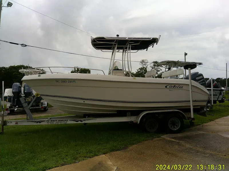The Image of 2007 Cobia 214 Center Console boat on trailer, parked outdoors. - 0