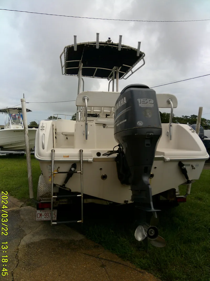 Slide: The Image of 2007 Cobia 214 CC boat with Yamaha 150 engine, docked on grass. - 18