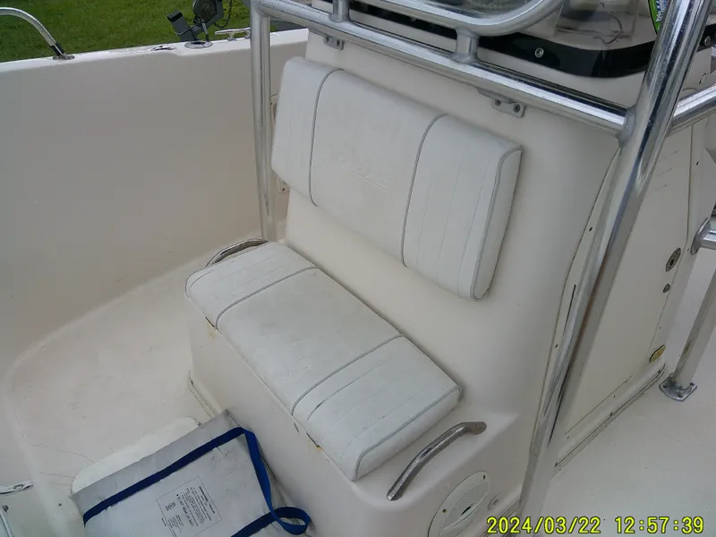 Slide: The Image of 2007 Cobia 214 CC boat interior with white seating and metal railings. - 5
