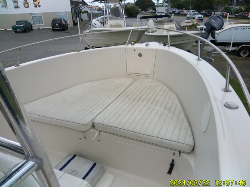 Slide: The Image of 2007 Cobia 214 CC boat seating area with white cushions and stainless steel frame. - 6