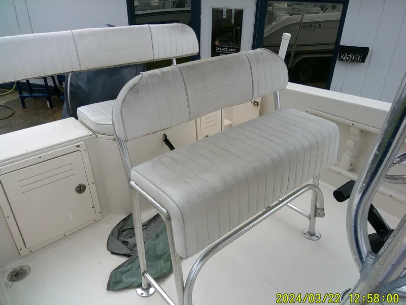 Slide: The Image of 2007 Cobia 214 CC boat interior with seating and console, docked near other boats. - 8
