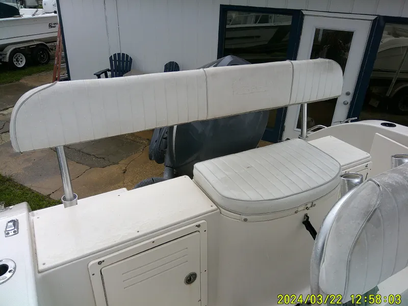 Slide: The Image of 2007 Cobia 214 CC boat interior with white cushioned seating and storage compartments. - 9