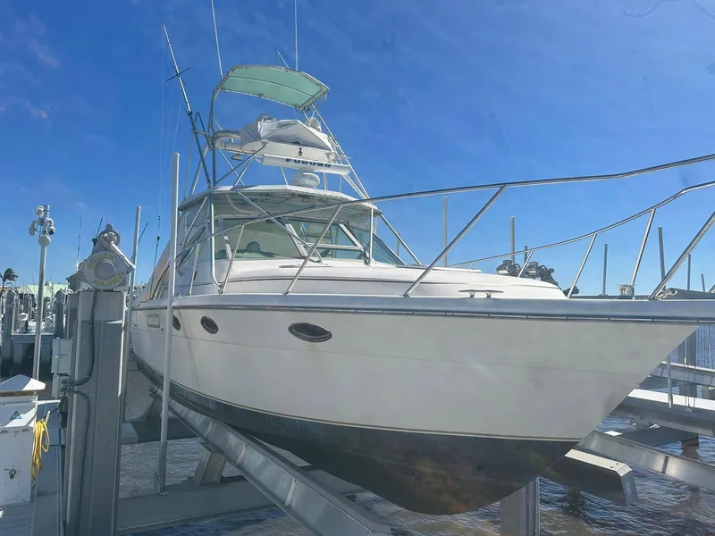 Slide: The Image of 1995 Tiara Sport 3100 boat docked under clear blue sky. - 1