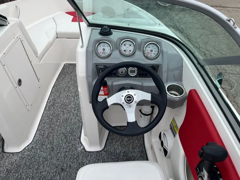 Slide: The Image of 2014 Chaparral 19 Sport H2O boat cockpit with steering wheel and gauges. - 11