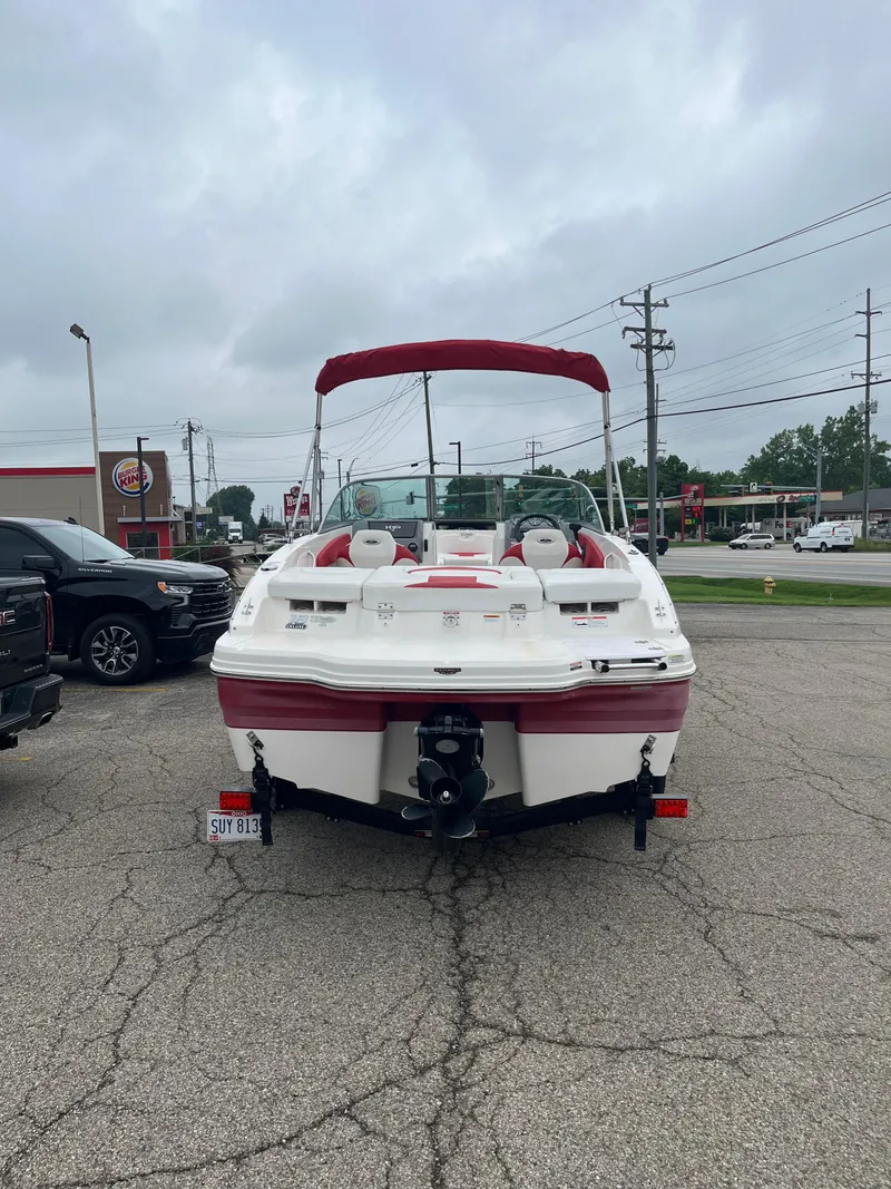 Slide: The Image of 2014 Chaparral 19 Sport H2O boat with red accents parked in a lot. - 2