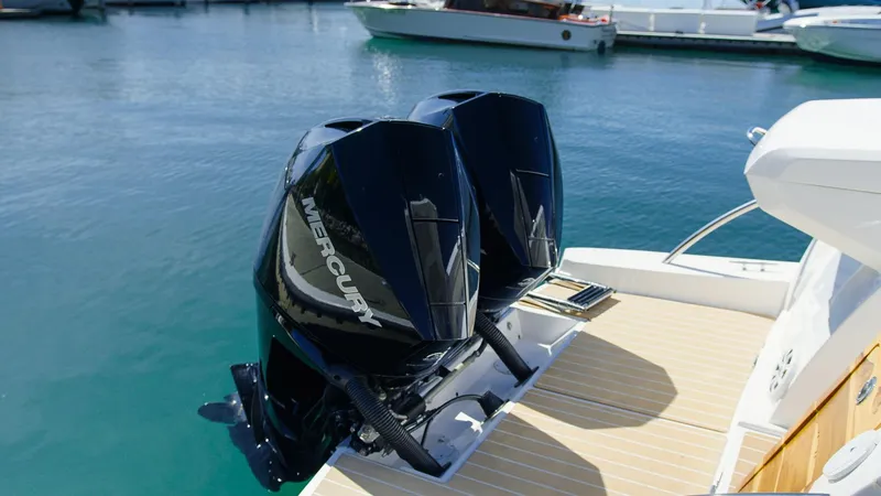 Slide: The Image of Twin Mercury outboard engines on a 2025 Ventura V300 Crossover boat, docked in clear water. - 4