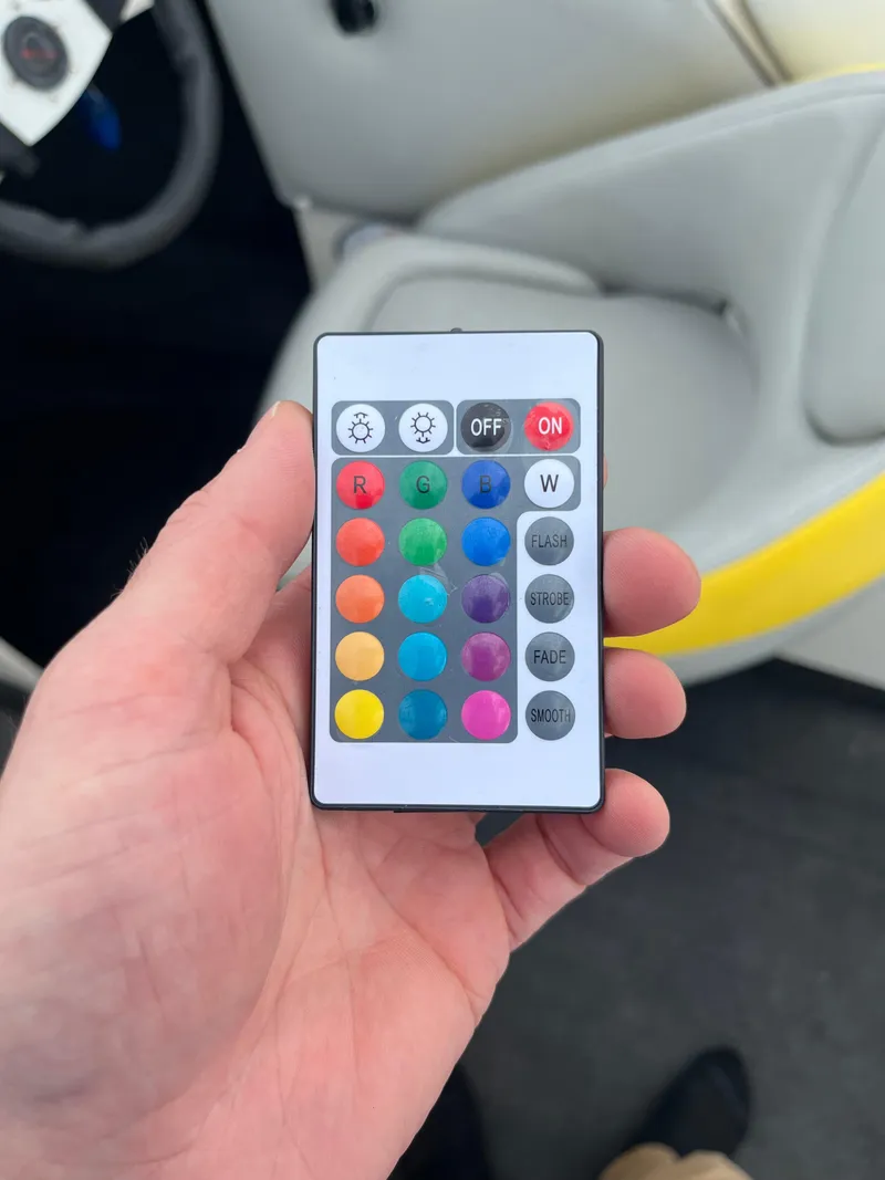 Slide: The Image of Hand holding a colorful remote control inside a 2004 Tigé 20V Limited Edition boat. - 16
