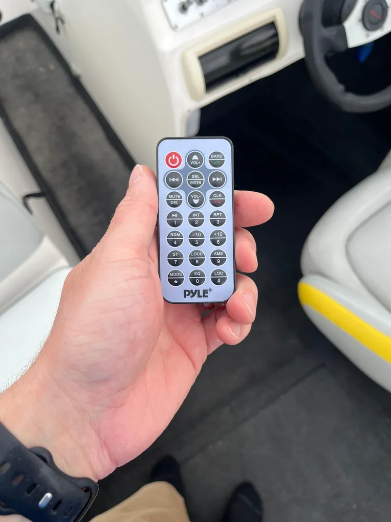 Slide: The Image of Hand holding Pyle remote control inside 2004 Tigé 20V Limited Edition boat. - 18