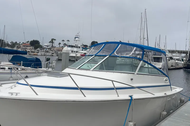Slide: The Image of 1992 Ocean Yachts Sport Cruiser docked at marina, featuring blue canopy and sleek design. - 11