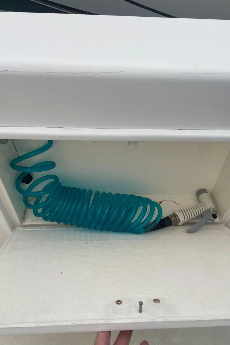 Slide: The Image of Coiled blue hose in storage compartment of 1992 Ocean Yachts Sport Cruiser. - 15
