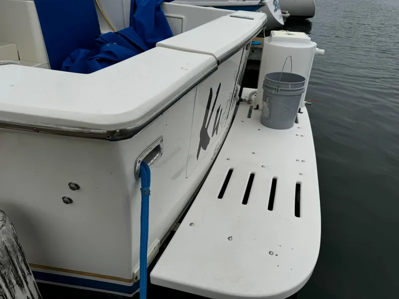 Slide: The Image of 1992 Ocean Yachts Sport Cruiser docked, featuring a white swim platform and blue rope. - 7