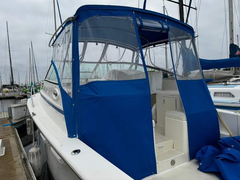 Slide: The Image of 1992 Ocean Yachts Sport Cruiser with blue canopy docked at marina. - 8