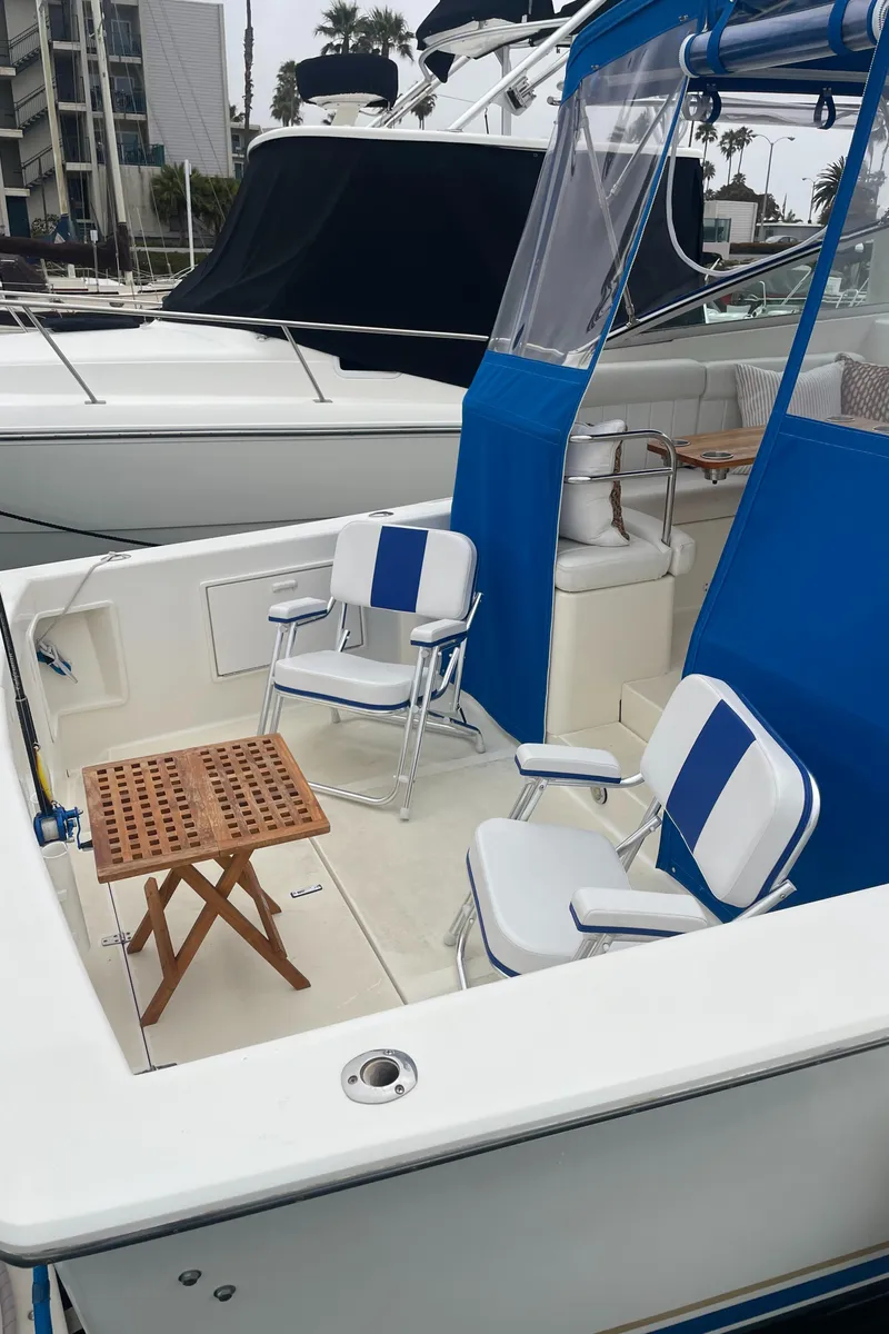 Slide: The Image of 1992 Ocean Yachts Sport Cruiser with blue seating and wooden table on deck. - 17