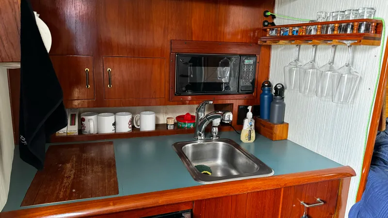Slide: The Image of 1992 Ocean Yachts Sport Cruiser kitchen with sink, microwave, and wooden cabinetry. - 3