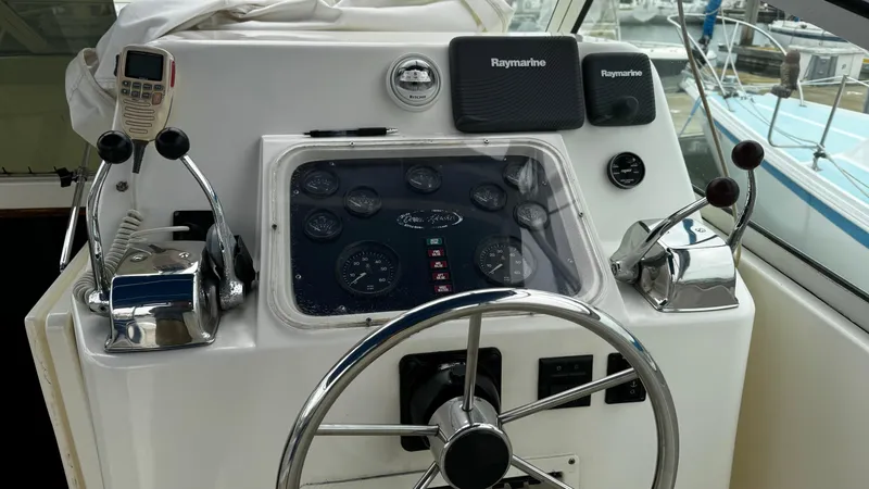 Slide: The Image of 1992 Ocean Yachts Sport Cruiser helm with steering wheel and navigation controls. - 9