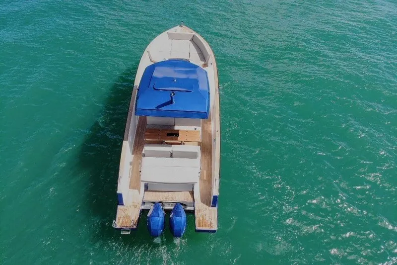 Slide: The Image of 2022 Tesoro T38 Outboard boat with blue canopy on turquoise water. - 18