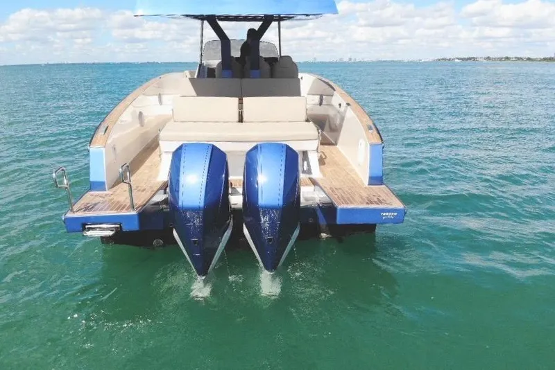 Slide: The Image of 2022 Tesoro T38 Outboard boat on clear blue water, rear view with twin engines. - 23