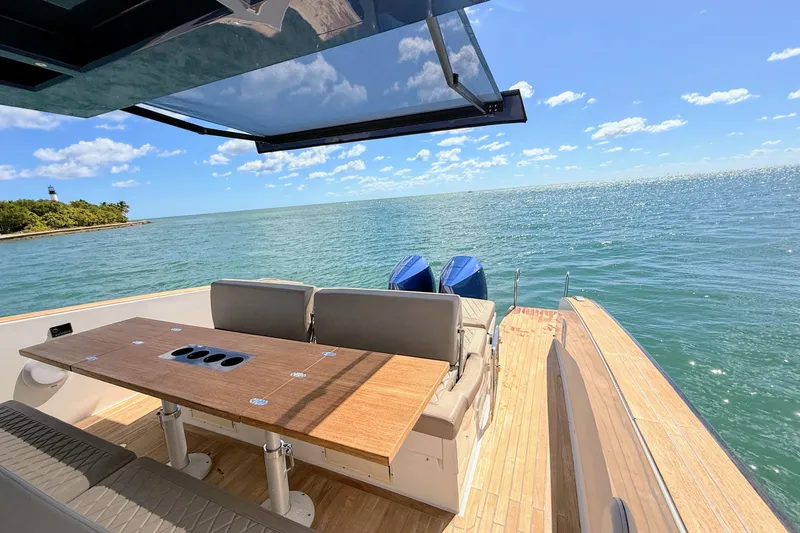 Slide: The Image of 2022 Tesoro T38 Outboard boat with ocean view, featuring a wooden deck and seating area. - 25