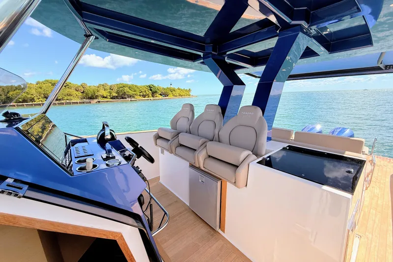 Slide: The Image of 2022 Tesoro T38 Outboard boat interior with luxurious seating and modern controls, overlooking serene waters. - 3
