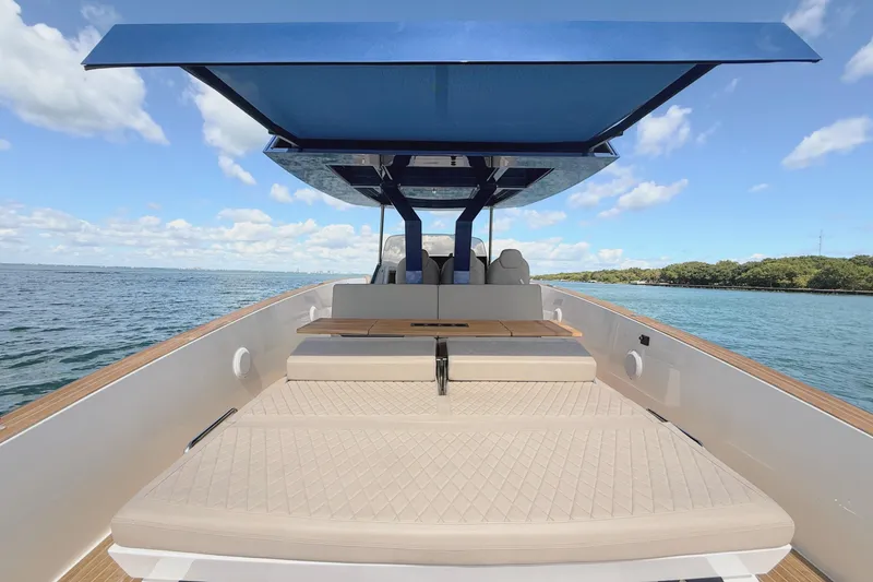 Slide: The Image of 2022 Tesoro T38 Outboard boat with sunshade, beige seating, and scenic water view. - 4