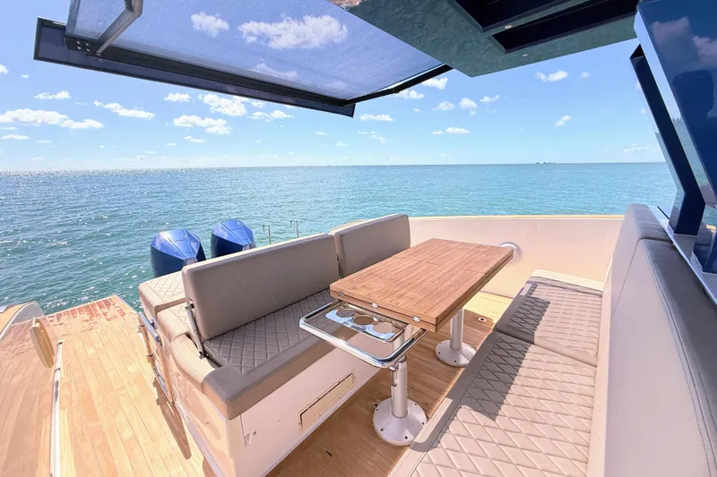 Slide: The Image of 2022 Tesoro T38 Outboard boat interior with seating and table, overlooking the ocean. - 40