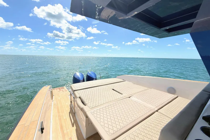 Slide: The Image of 2022 Tesoro T38 Outboard boat with sun deck, ocean view, and clear blue sky. - 43
