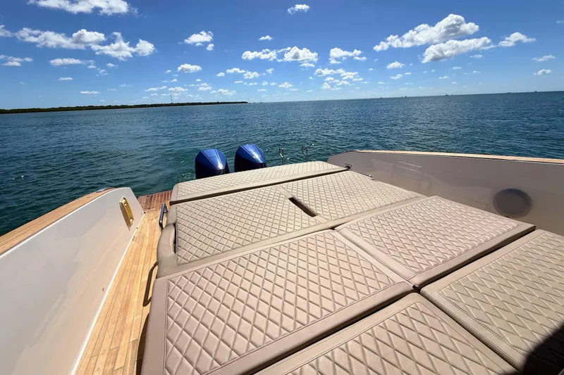 Slide: The Image of 2022 Tesoro T38 Outboard boat with sunbathing deck, ocean view, and clear blue sky. - 56