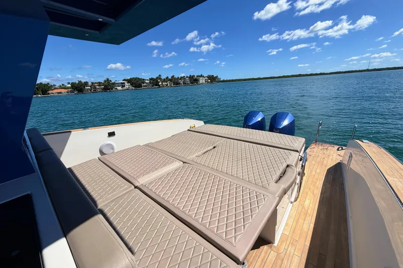 Slide: The Image of Luxurious 2022 Tesoro T38 Outboard boat with sunbed, overlooking serene blue waters. - 57