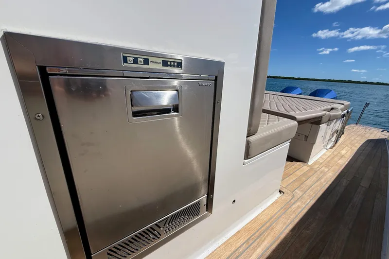 Slide: The Image of 2022 Tesoro T38 Outboard boat with stainless steel appliance and cushioned seating by the water. - 59