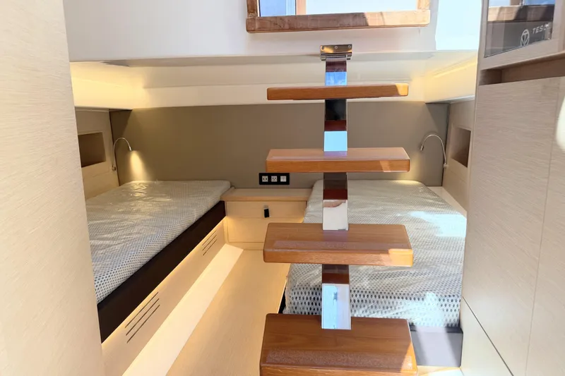 Slide: The Image of 2022 Tesoro T38 Outboard cabin interior with twin beds and wooden steps. - 63