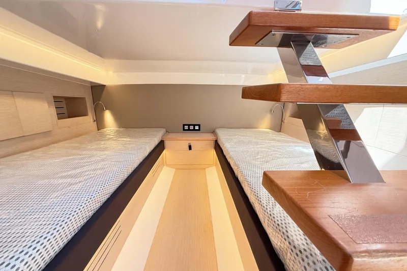 Slide: The Image of 2022 Tesoro T38 Outboard cabin interior with twin beds and modern wooden staircase. - 64