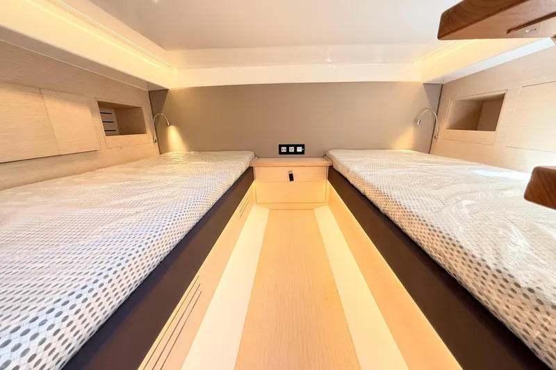 Slide: The Image of 2022 Tesoro T38 Outboard cabin interior with twin beds and modern lighting. - 65