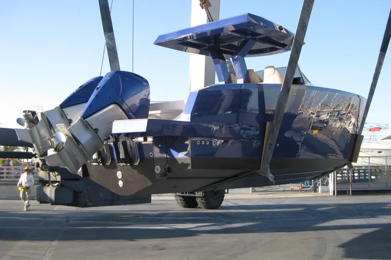 Slide: The Image of 2022 Tesoro T38 Outboard boat suspended in a shipyard, showcasing sleek design and powerful engines. - 68