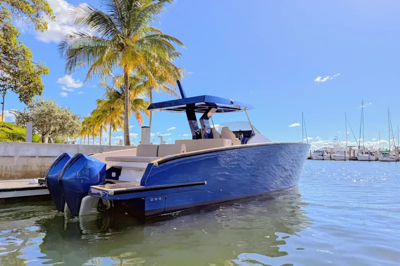 Slide: The Image of 2022 Tesoro T38 Outboard boat docked near palm trees and marina. - 7