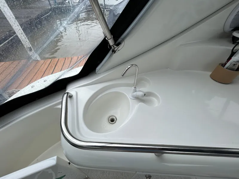 Slide: The Image of 2001 Cruisers Yachts 3470 Express sink area with faucet and railing. - 14