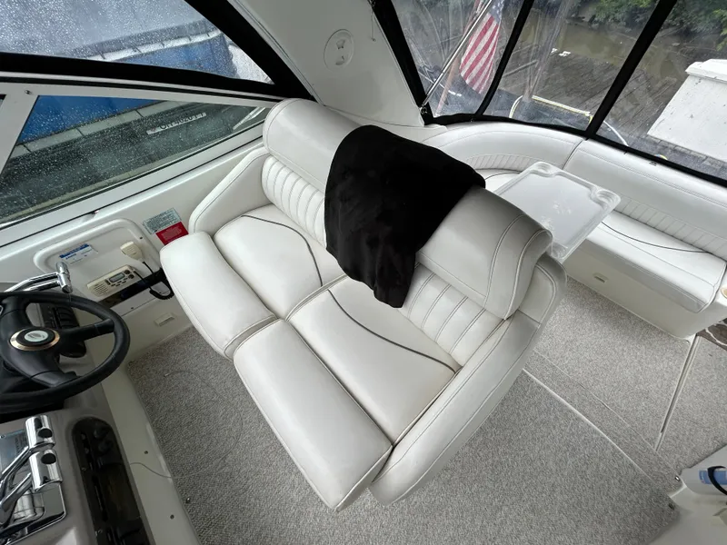 Slide: The Image of 2001 Cruisers Yachts 3470 Express interior with white leather seating and steering wheel. - 19