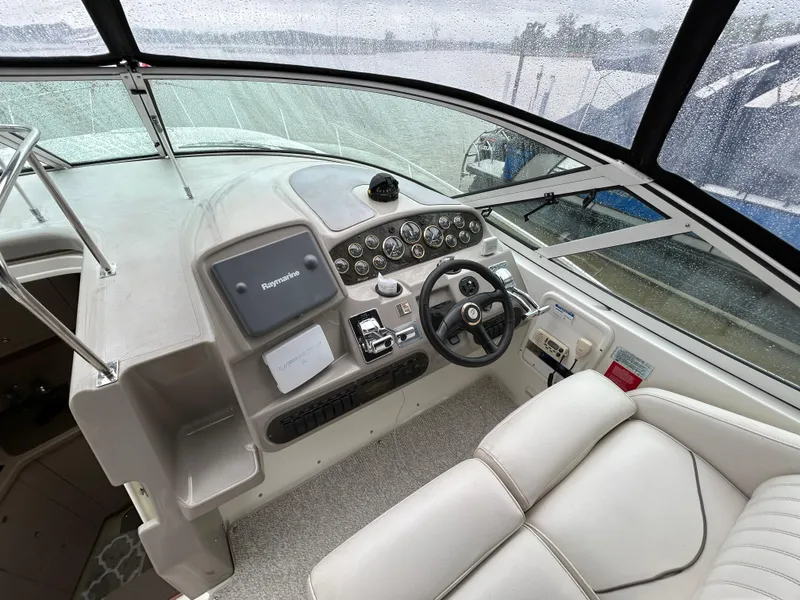 Slide: The Image of 2001 Cruisers Yachts 3470 Express helm with steering wheel and navigation controls. - 20