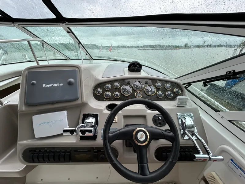 Slide: The Image of 2001 Cruisers Yachts 3470 Express helm with Raymarine and Lowrance equipment, rainy day view. - 21